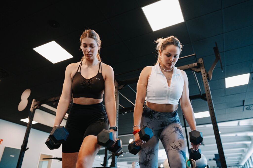 Zwei junge Frauen trainieren ihre Beine mit Gewichten im Lifestyle 